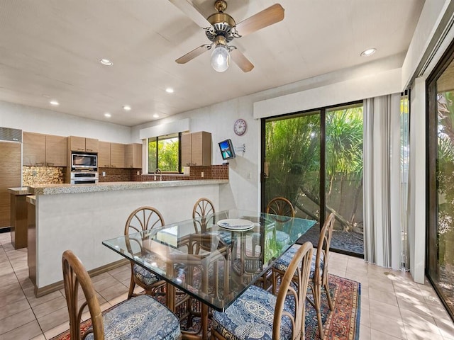 tiled dining area with ceiling fan and sink