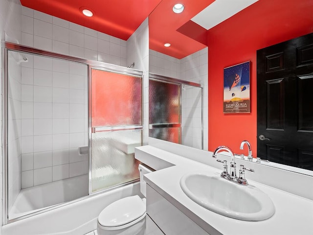 full bathroom with vanity, combined bath / shower with glass door, and toilet