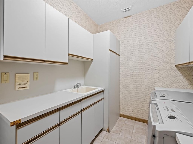 kitchen featuring white cabinetry, washer / dryer, sink, and light tile patterned floors