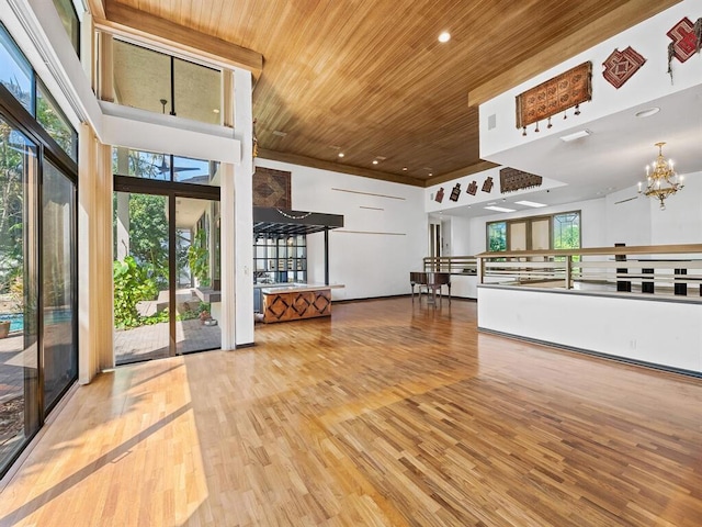 kitchen featuring a healthy amount of sunlight, hardwood / wood-style floors, wood ceiling, and an inviting chandelier