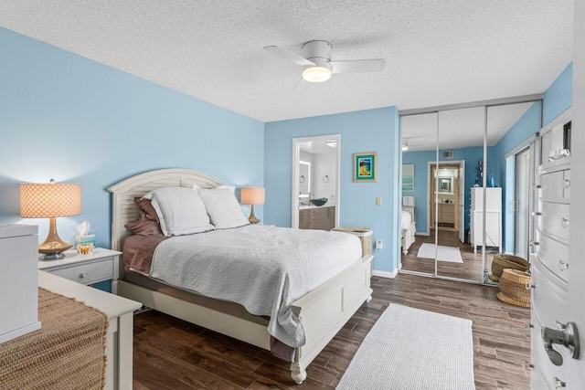 bedroom featuring ceiling fan, dark wood-type flooring, a textured ceiling, and ensuite bath