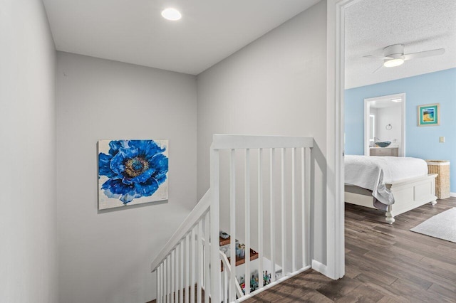 stairway with wood-type flooring and ceiling fan