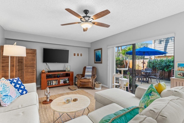 living room featuring ceiling fan, a textured ceiling, and light tile patterned floors