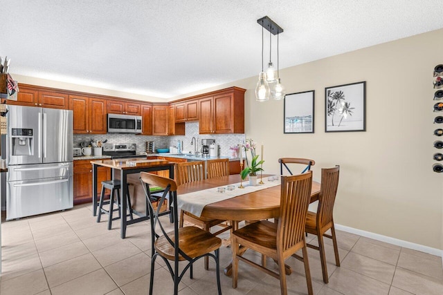 tiled dining space with sink and a textured ceiling