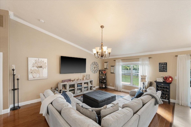 living room featuring vaulted ceiling, ornamental molding, a chandelier, and hardwood / wood-style floors