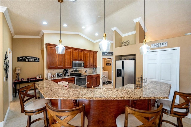 kitchen with light stone counters, decorative light fixtures, and appliances with stainless steel finishes