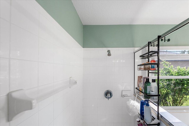 bathroom featuring a textured ceiling and tiled shower