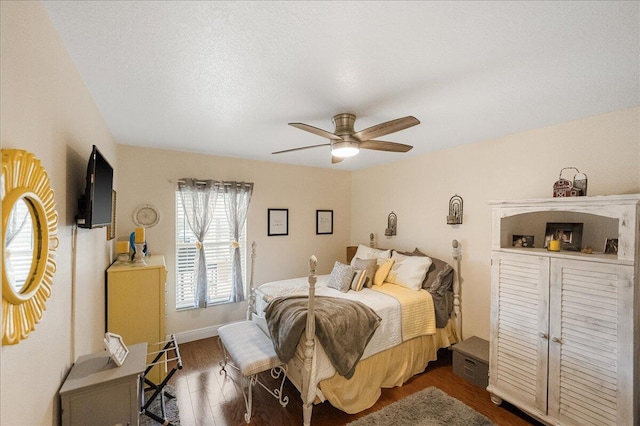 bedroom with ceiling fan, dark hardwood / wood-style floors, and a textured ceiling