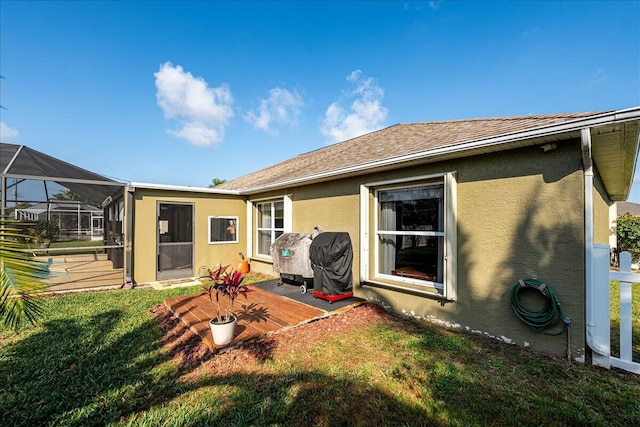 back of house with a lanai and a yard