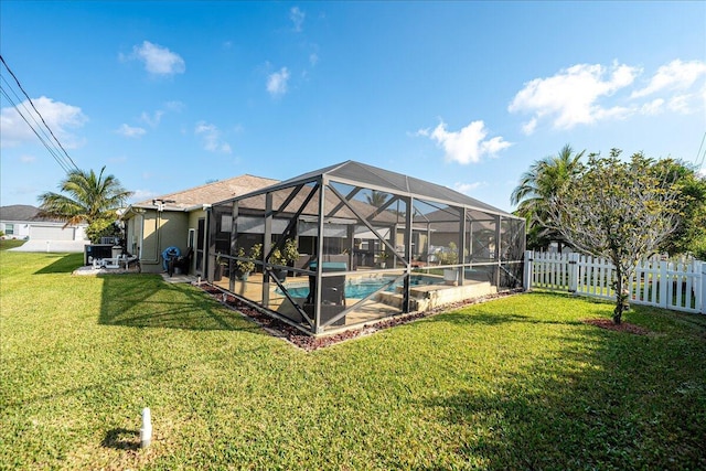 view of swimming pool featuring a yard, a patio, and glass enclosure