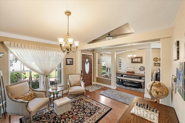 sitting room with hardwood / wood-style flooring, vaulted ceiling, and a chandelier