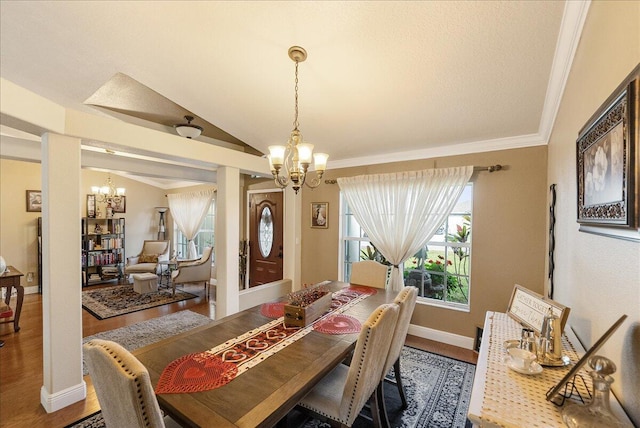 dining space featuring hardwood / wood-style flooring, vaulted ceiling, a notable chandelier, and crown molding