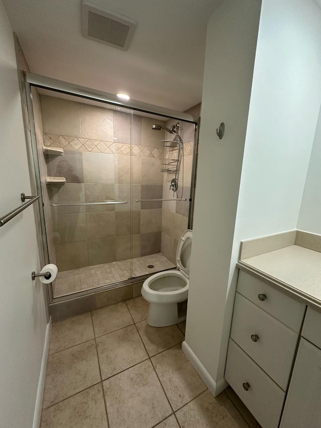 bathroom featuring tile patterned floors, a shower with door, and toilet