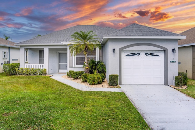 single story home with a garage, a front lawn, a shingled roof, and stucco siding