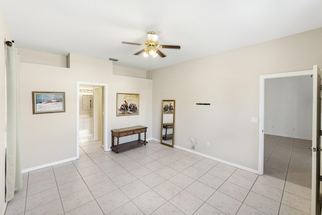 empty room featuring light tile patterned floors, ceiling fan, visible vents, and baseboards