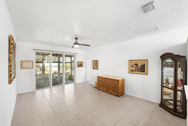 tiled spare room featuring ceiling fan and a textured ceiling