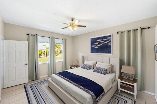 bedroom featuring ceiling fan, baseboards, and light tile patterned floors