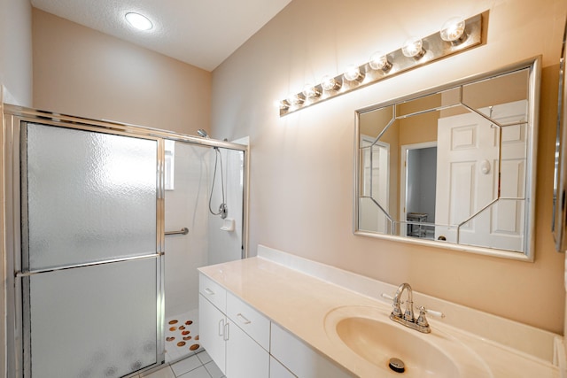 full bathroom featuring tile patterned flooring, a shower stall, and vanity