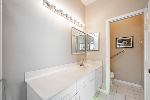 bathroom with toilet, vanity, baseboards, and tile patterned floors