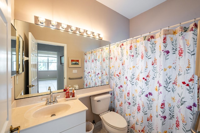 full bath with curtained shower, vanity, and toilet