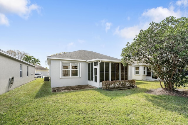 rear view of house featuring a lawn, a sunroom, and central air condition unit