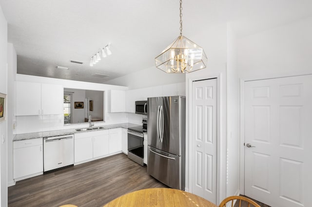 kitchen with pendant lighting, stainless steel appliances, sink, and white cabinets