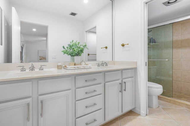 bathroom with tile patterned flooring, vanity, a shower with door, and toilet