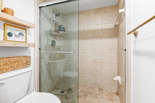 bathroom with a shower with door and toilet