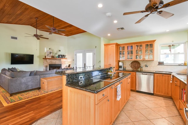 kitchen featuring visible vents, black electric stovetop, vaulted ceiling, and stainless steel dishwasher