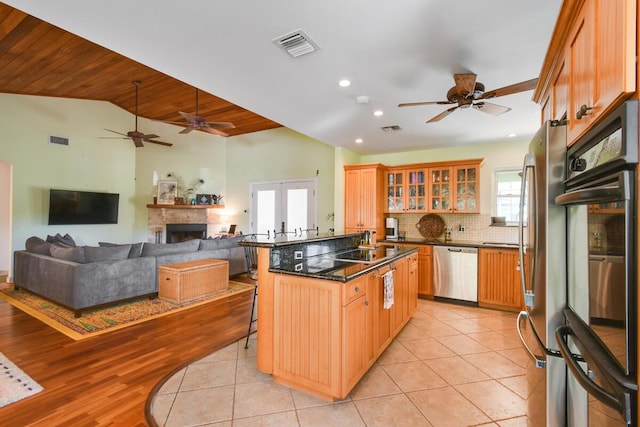 kitchen with light tile patterned floors, appliances with stainless steel finishes, dark countertops, and visible vents