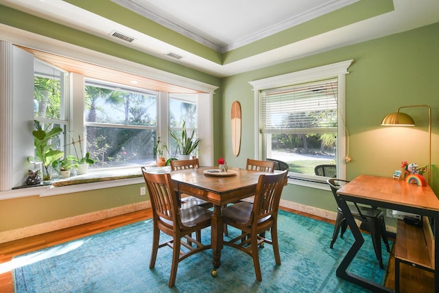 dining area featuring ornamental molding, wood finished floors, visible vents, and baseboards