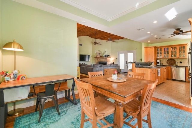 dining room with visible vents, lofted ceiling, ornamental molding, a fireplace, and recessed lighting