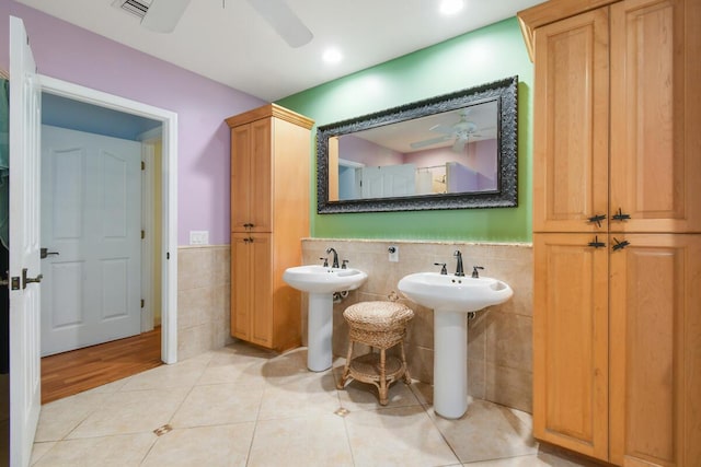 full bath with visible vents, a ceiling fan, wainscoting, tile patterned flooring, and tile walls