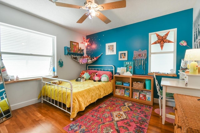 bedroom featuring a ceiling fan, baseboards, and wood finished floors