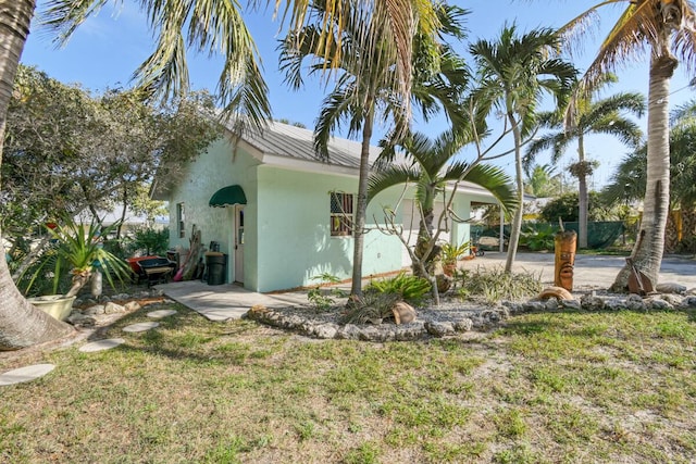 view of side of home featuring a yard and stucco siding