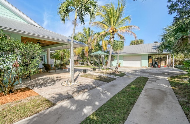 exterior space featuring a patio, metal roof, driveway, and ceiling fan