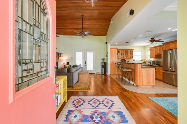 foyer entrance with french doors, wooden ceiling, ceiling fan, and light wood-style flooring