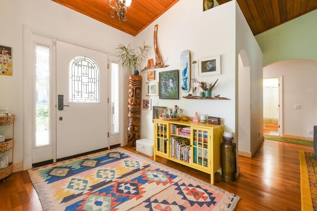 foyer entrance with wooden ceiling, arched walkways, and vaulted ceiling