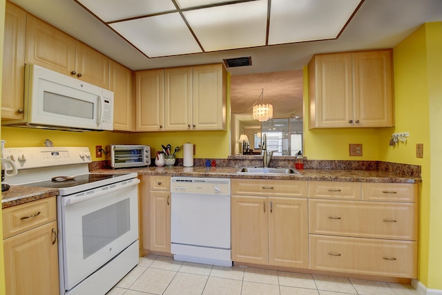 kitchen featuring light brown cabinetry, sink, light tile patterned floors, a notable chandelier, and white appliances