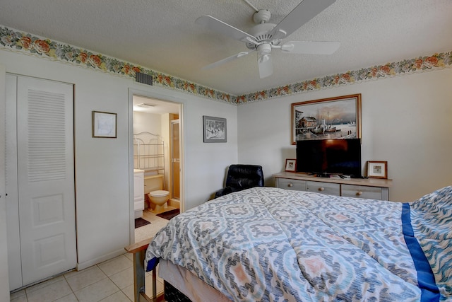 tiled bedroom featuring connected bathroom, a textured ceiling, and ceiling fan