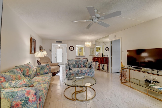 living room featuring ceiling fan and a textured ceiling