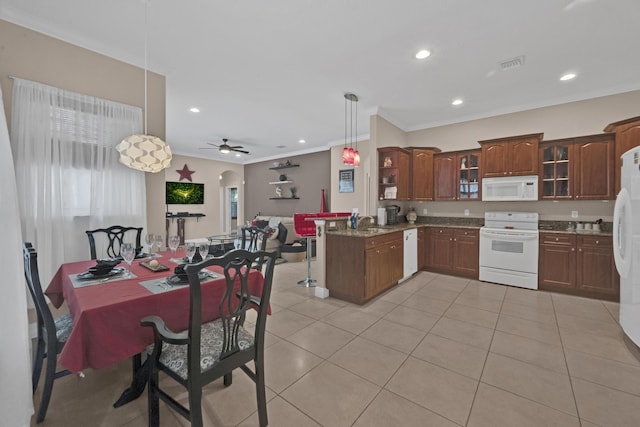 kitchen with pendant lighting, kitchen peninsula, white appliances, and light tile patterned floors