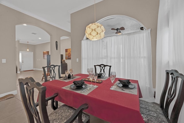 dining space featuring crown molding and light tile patterned flooring