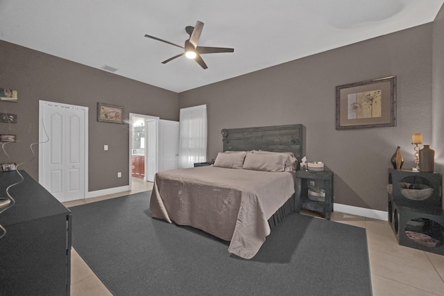 bedroom with ensuite bathroom, ceiling fan, and light tile patterned flooring