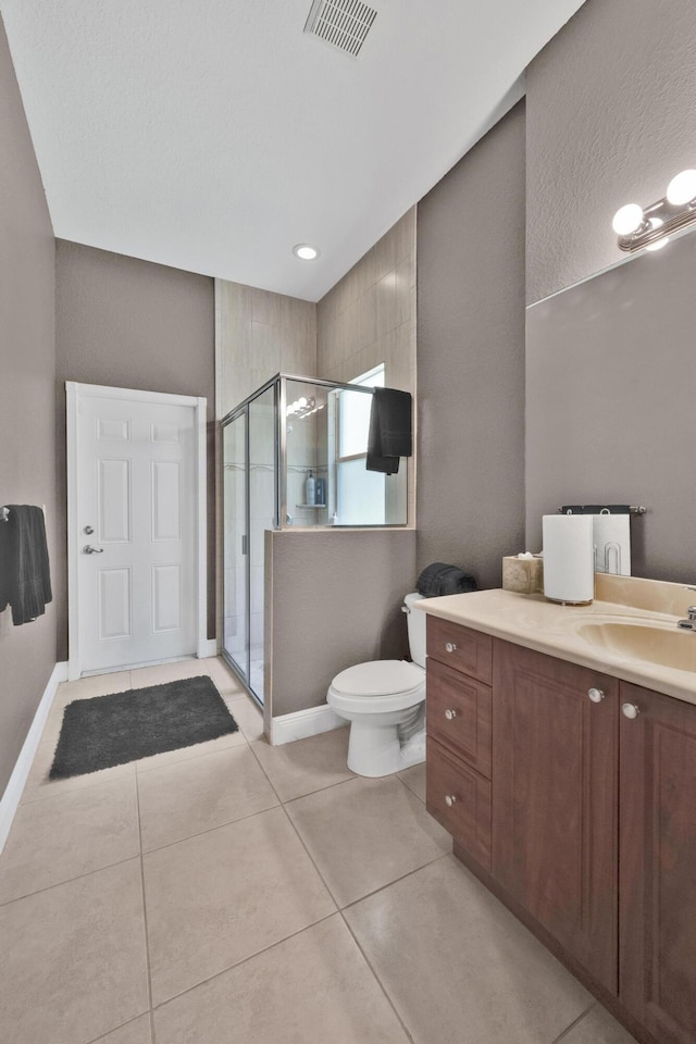 bathroom with walk in shower, vanity, toilet, and tile patterned flooring