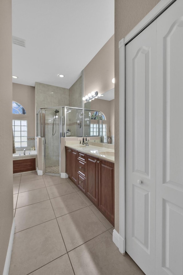 bathroom with tile patterned flooring, vanity, separate shower and tub, and a wealth of natural light