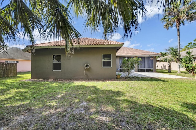 back of property with a yard and a patio area