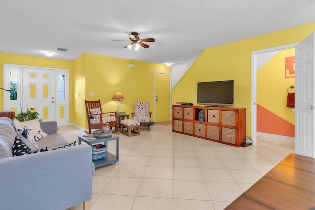 tiled living room with ceiling fan and a textured ceiling