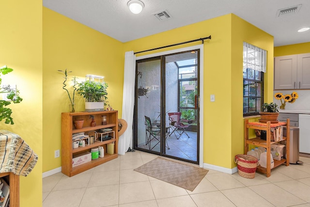 doorway to outside with light tile patterned floors