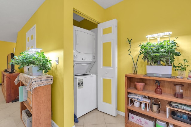 washroom featuring stacked washer and clothes dryer and light tile patterned floors